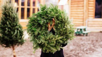 christmas wreath held by human by getty images