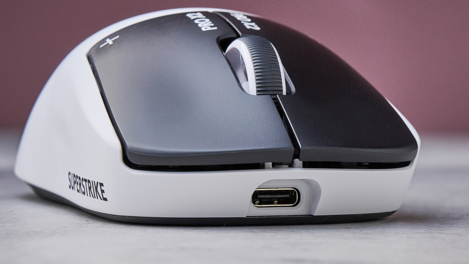 Front close-up of Logitech G Pro X2 Superstrike on white desk with pink wall in background