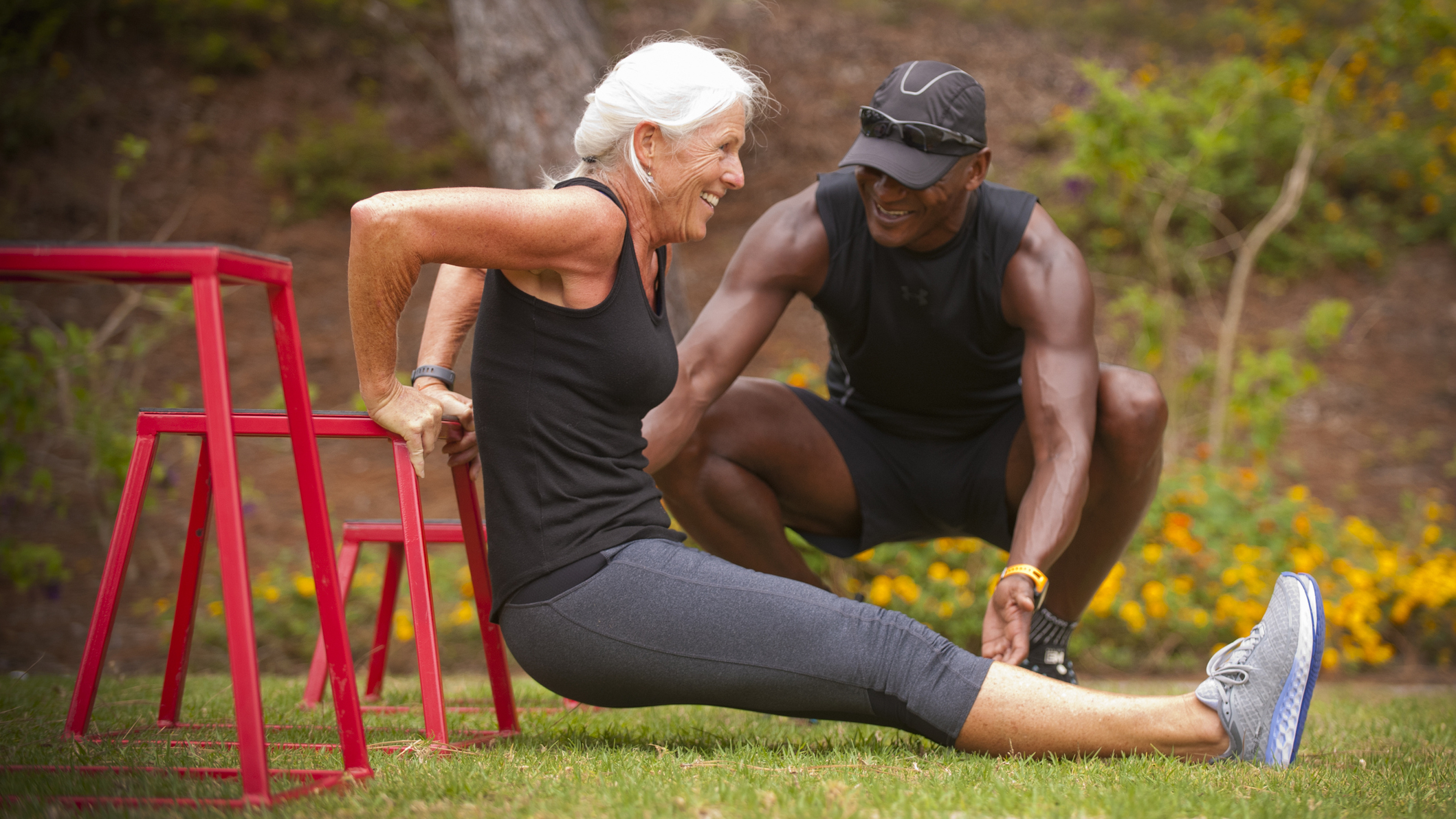 Senior woman exercising outdoor with personal trainer