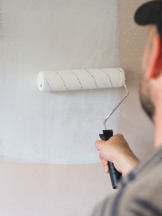 painting new plaster with a roller