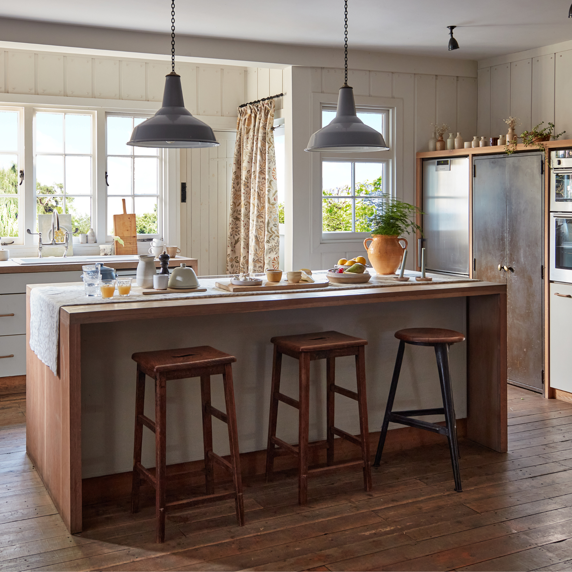 a kitchen with a large kitchen island and stools in front of it