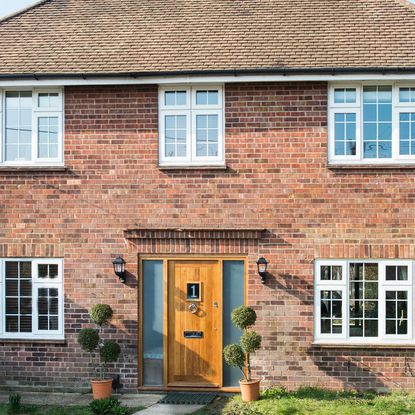 house exterior with red brick wall and front garden