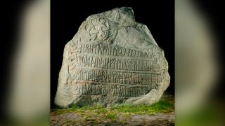 Large boulder, known as the Jelling Stone, covered in runes.