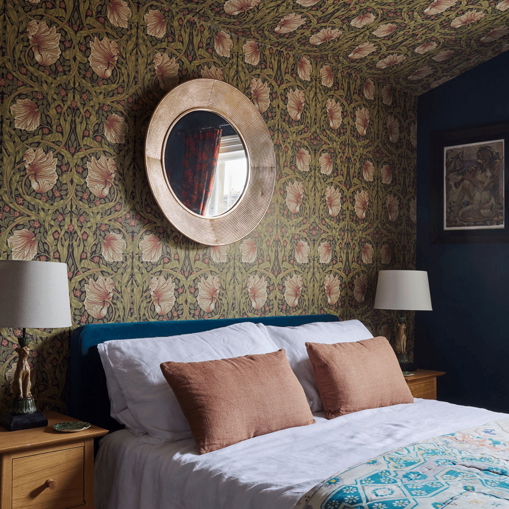Wallpapered bedroom with mirror above bed