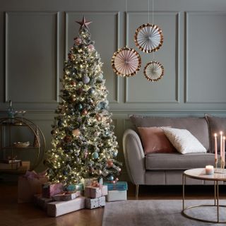 Blue wall paneling behind contemporary Christmas tree with 3-seater plush pebble grey sofa