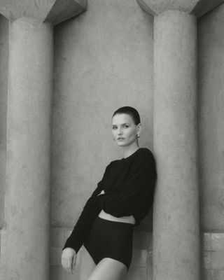 Model wears black against backdrop of Moroccan hotel