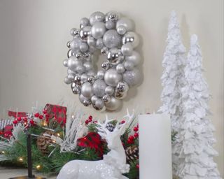 Christmas bauble wreath on wall with reindeer on mantlepeice