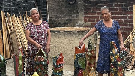 Laura Enriquez Chávez and Asunción Enriquez Chávez standing among their ceramic vessels in their Oaxaca workshop