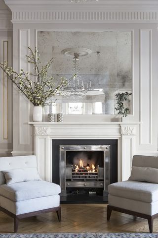 elegant white living room with antique mirror and fireplace