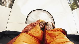 Couple inside sleeping bags and tent