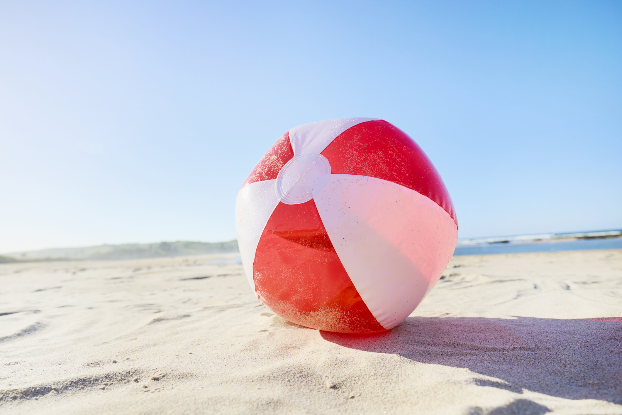 red and white beach ball on the sand