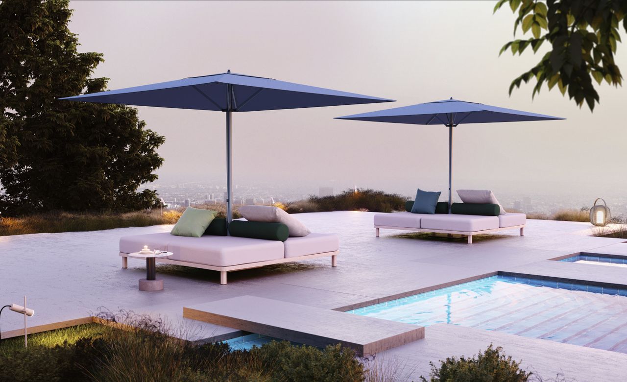 ‘Meteo’ garden parasol by Konstantin Grcic for Kettal. Two blue parasols with white sofas below them next to a pool with a view of the city below.