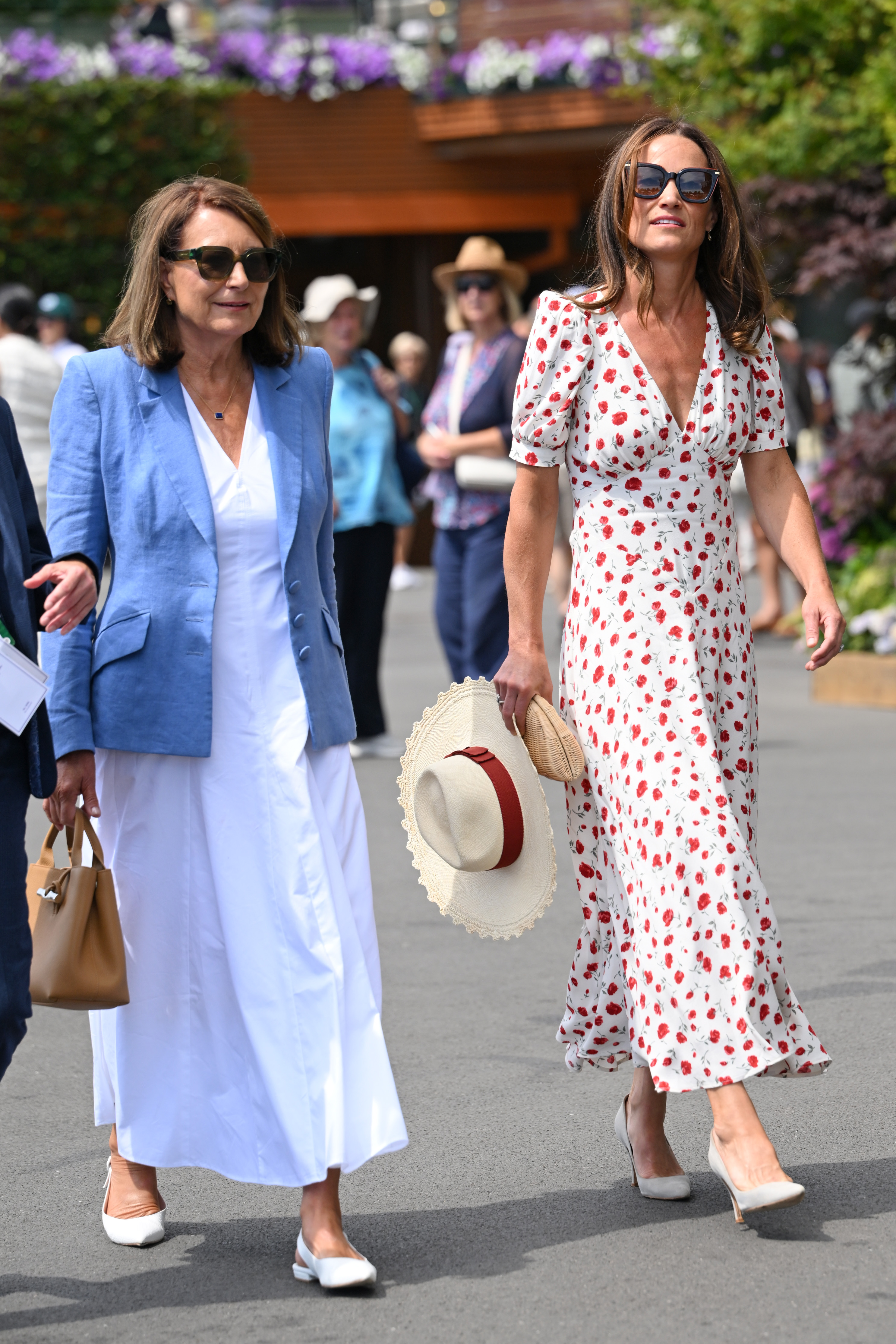 Carole Middleton in a white dress walking with Pippa Middleton at Wimbledon