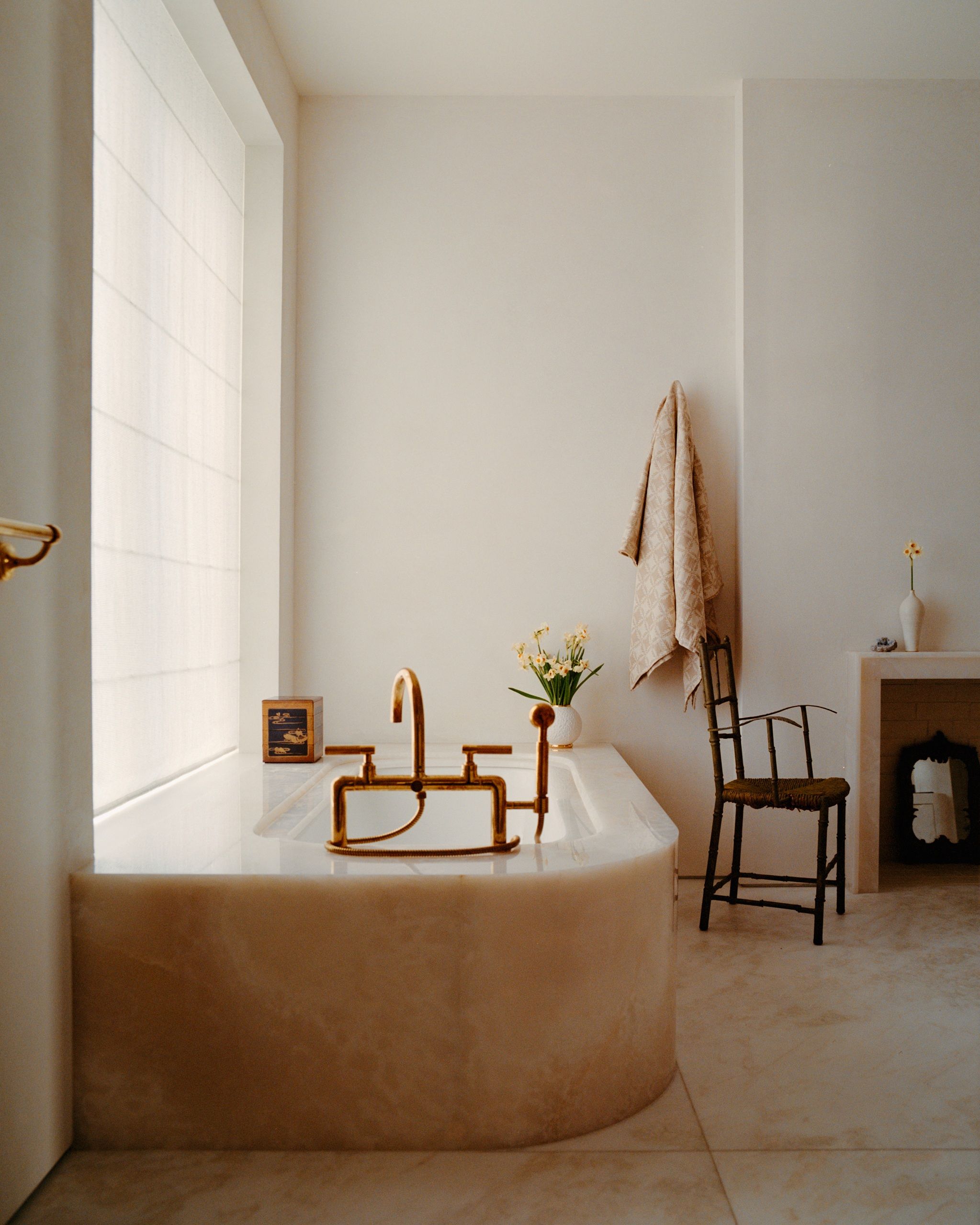 a bathroom with a large onyx bathtub and neutral white walls