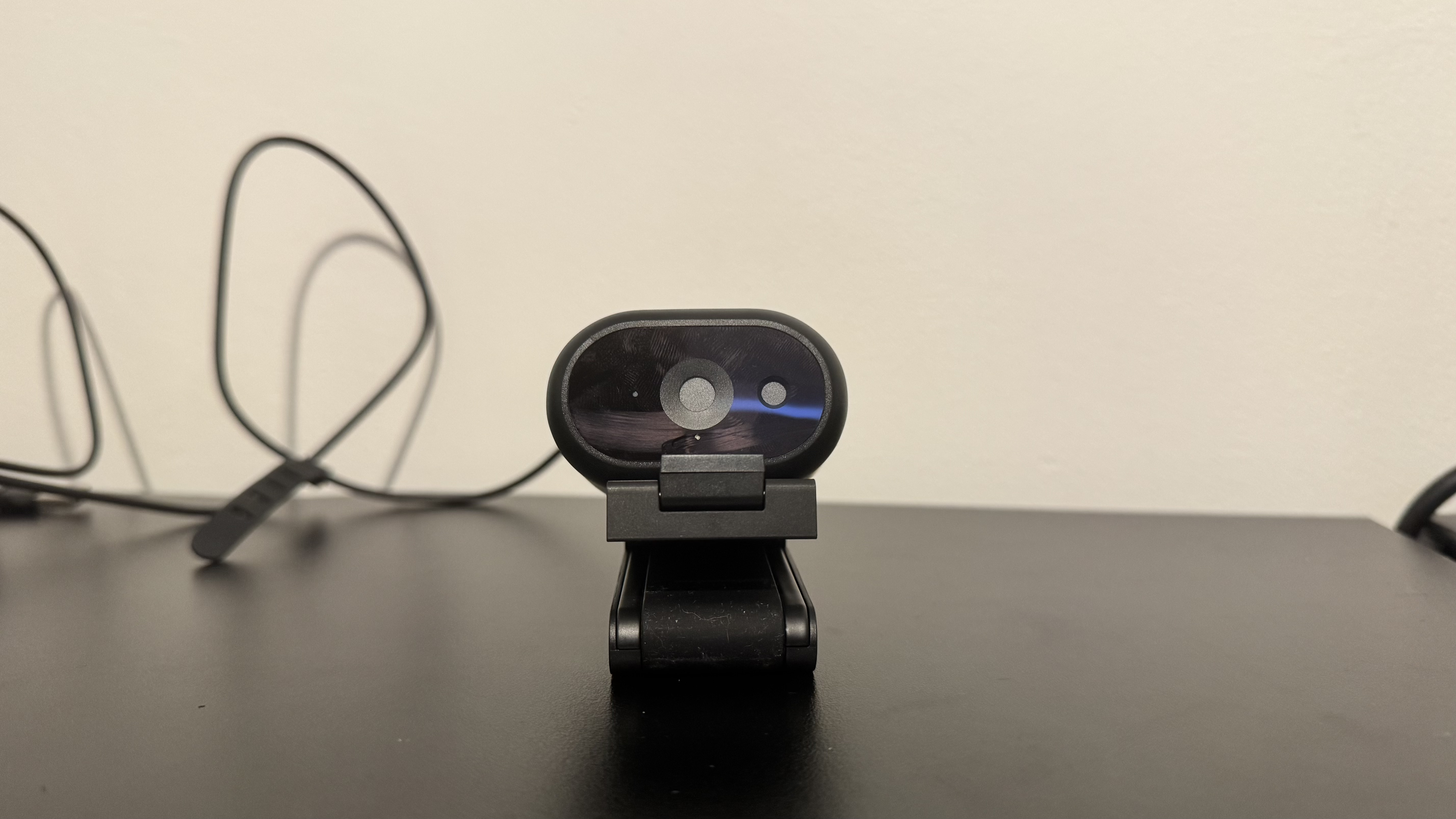 Dell Pro 5 webcam on its stand on top of a black desk