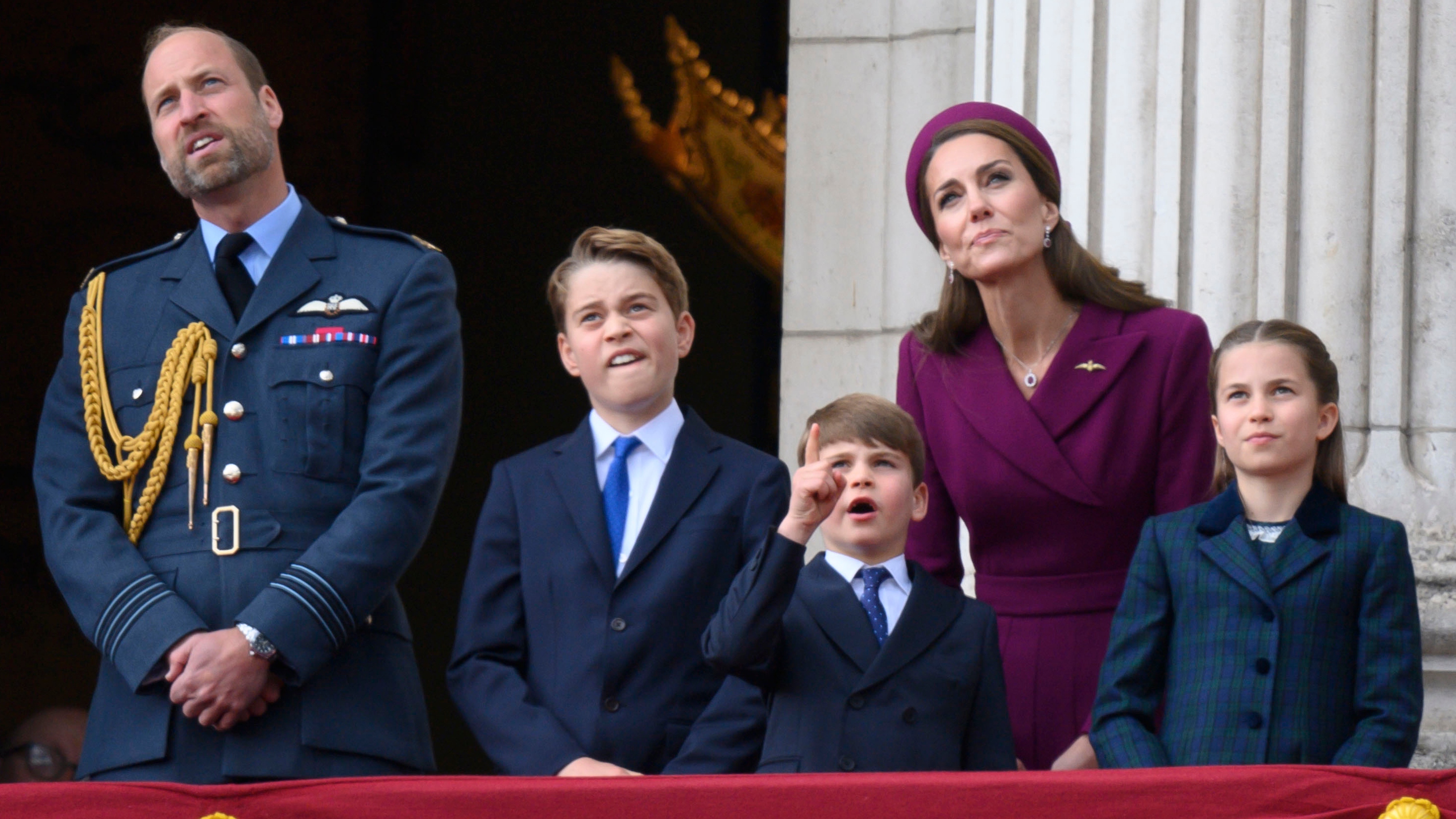 Prince William, Prince George, Prince Louis (pointing at the sky), Princess of Wales and Princess Charlotte appear on the balcony at Buckingham Palace to watch the flypast
