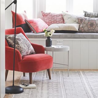 bench seat with cushions and red armchair