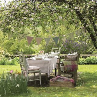 dining table and chairs in garden and plants and trees around