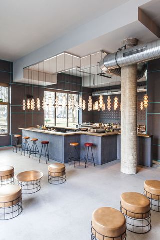 The Fantom bar which has round tables and chairs, pendant lights and a grey bar counter.