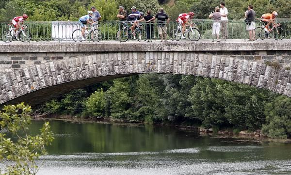 The bunch crosses an invitingly cool looking river.