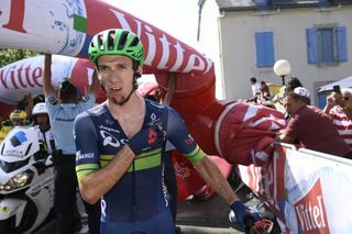 Adam Yates looking stunned after the inflatable flamme rouge banner collapsed on his front wheel