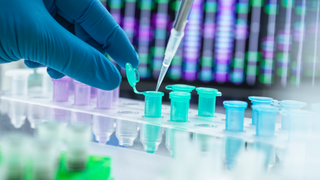 Scientist pipetting DNA sample into eppendorf tube.