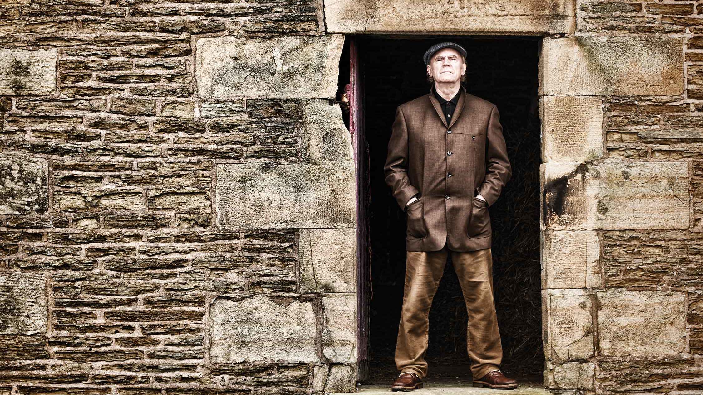 Ashley Hutchings poses in a brick doorway