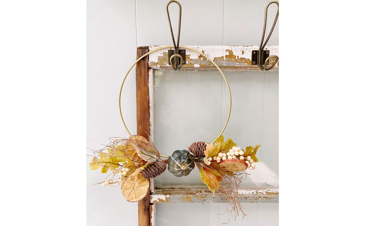 Simple fall gold hoop wreath hanging in hallway from small hook