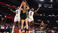 Caitlin Clark #22 of the Iowa Hawkeyes works to shoot around Sania Feagin #20 and Raven Johnson #25 of the South Carolina Gamecocks in the 2024 NCAA Women's Basketball Tournament National Championship at Rocket Mortgage FieldHouse