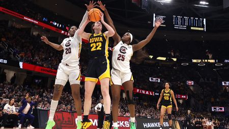 Caitlin Clark #22 of the Iowa Hawkeyes works to shoot around Sania Feagin #20 and Raven Johnson #25 of the South Carolina Gamecocks in the 2024 NCAA Women's Basketball Tournament National Championship at Rocket Mortgage FieldHouse