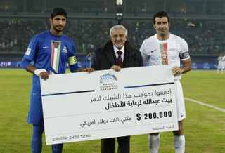 Musaed Neda (left) of the Kuwait XI team and Luis Figo (right) of the World Stars XI team pose prior to the Kuwait Champions Challenge match between a Football Champions Tour team and a Kuwait All-Stars team in December 2015.