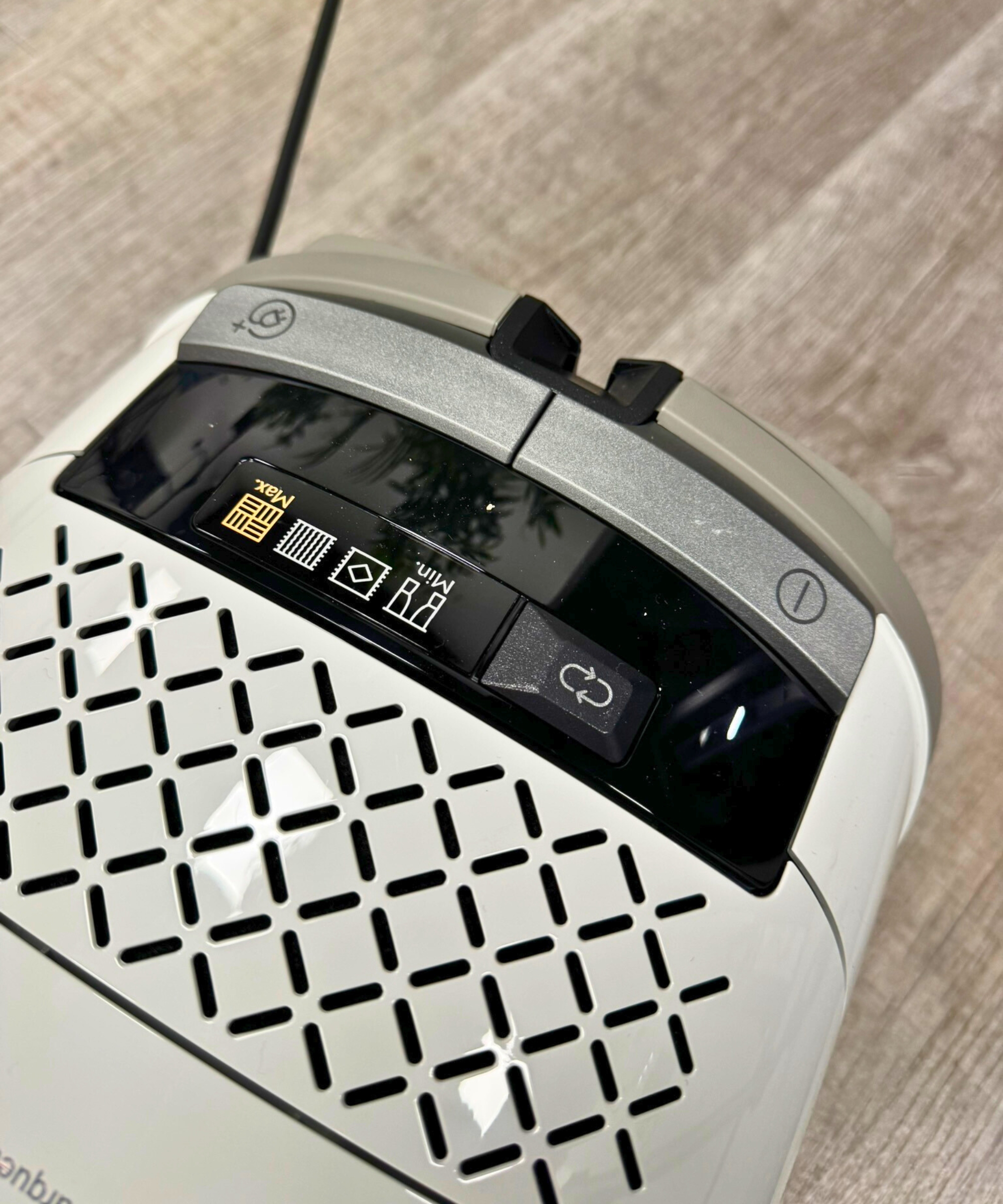 Closeup of Miele Guard M1 Parquet XL Brilliant canister vacuum, showing four suction modes, and power, mode, and cable pullback buttons.