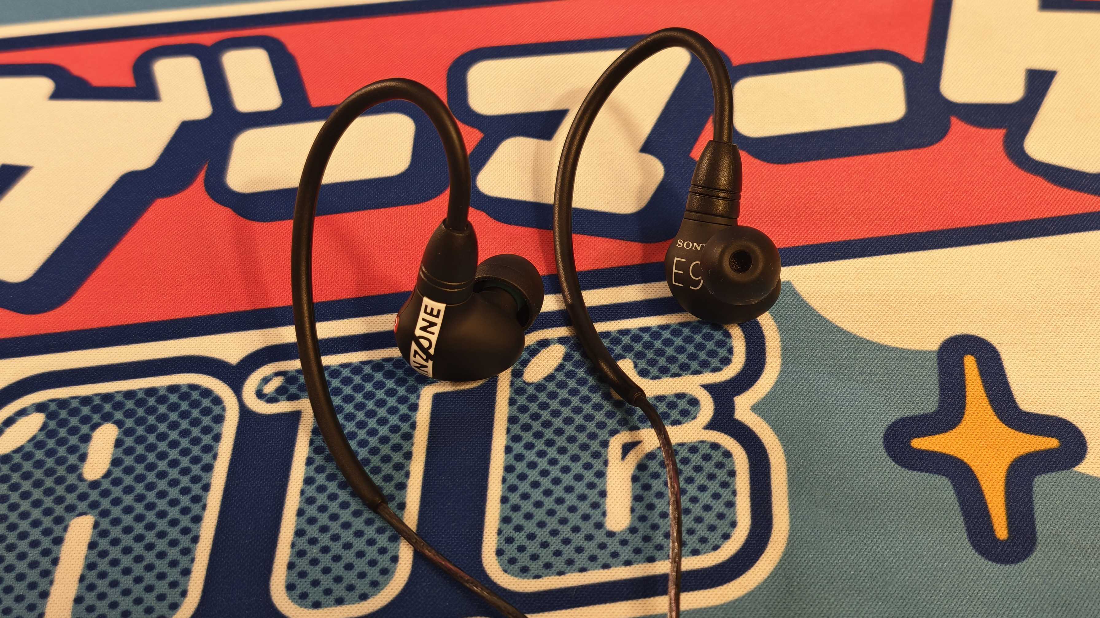 The Sony Inzone E9 gaming earbuds on a colorful desk mat.
