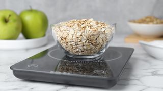 Rolled oats in a glass bowl on a digital scale
