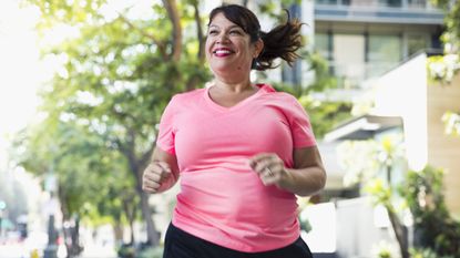 a woman jogging outside along a sunny urban street