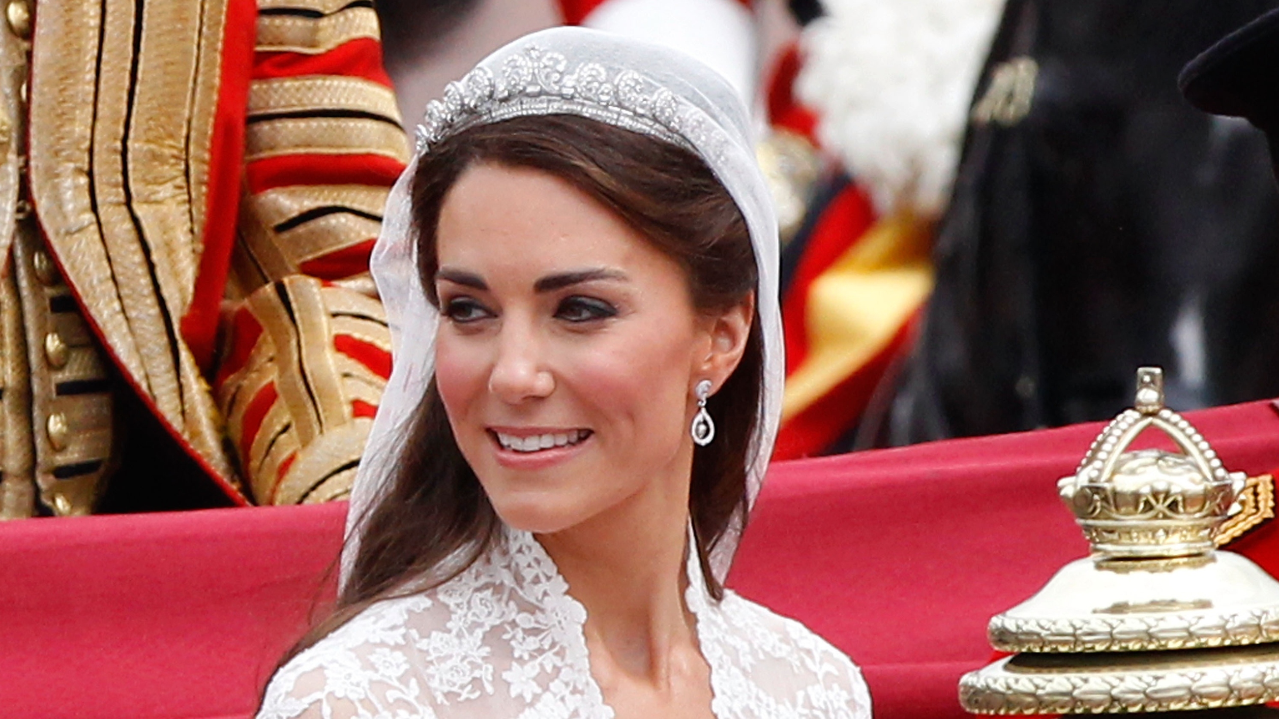 Catherine, Princess of Wales smiles at the cheering crowds as she makes the journey by carriage procession to Buckingham Palace on her wedding day