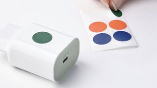 An IKEA fast charger on a table next to colored stickers