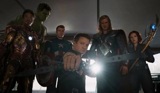 The Avengers standing in front of Loki, with Hawkeye aiming his bow and arrow at the camera