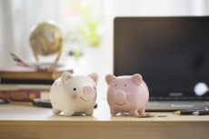 Two piggy banks on working table top.