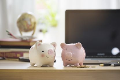 Two piggy banks on working table top.