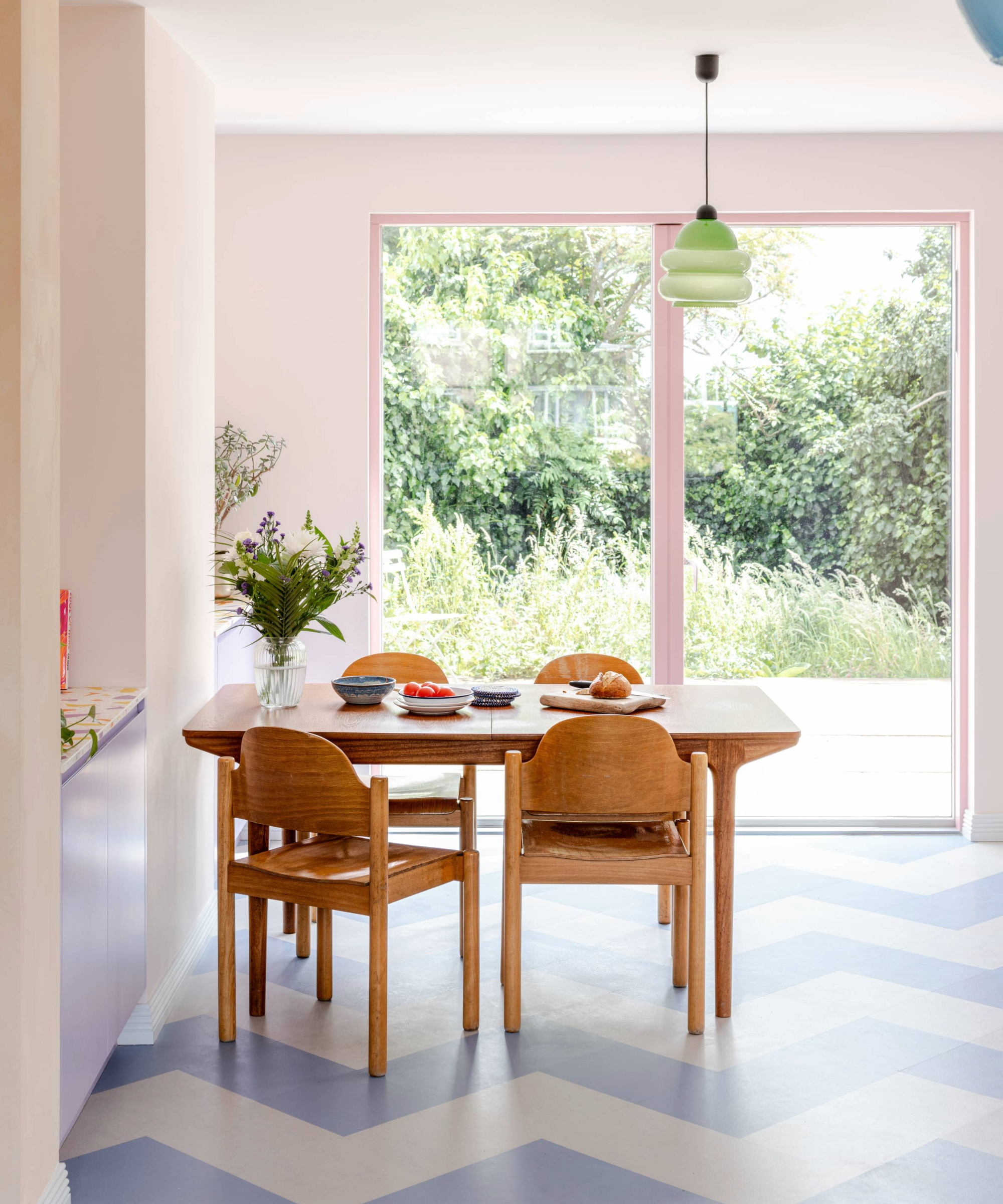 Room with dining room table, blue and white patterned flooring and patio doors with a pink rim