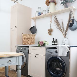 Utility area of a kitchen with washing machine, tumble dryer, cabinets and shelving