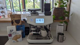 The Breville Barista Touch Impress coffee machine with coffee cup pouring espresso.