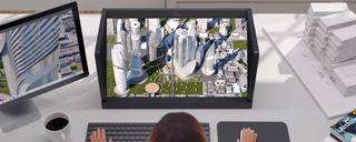 Sony's 27 Inch Spatial Reality Display showing a futuristic city while a person uses a computer in front of it.