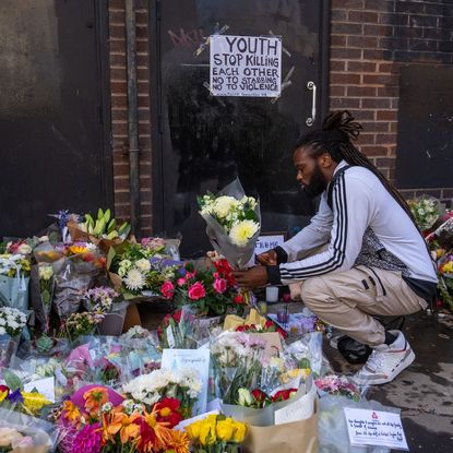 A man lays flowers at the scene of Elianne Andam's murder in Croydon