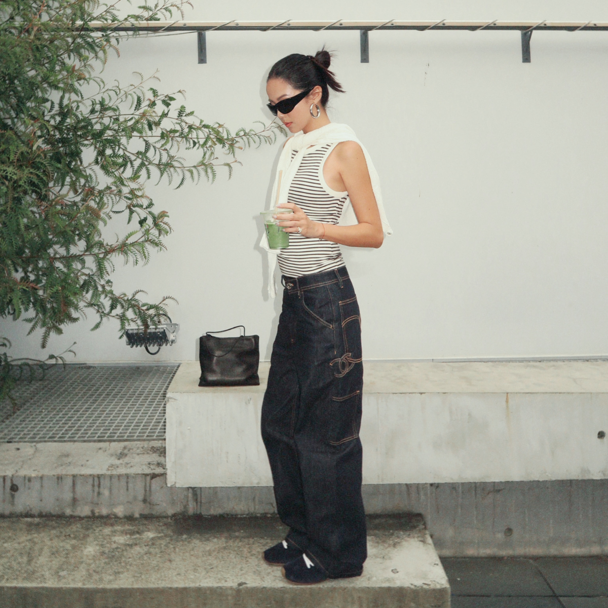 Influencer YOYO CAO wearing indigo jeans and suede navy trainers. 
