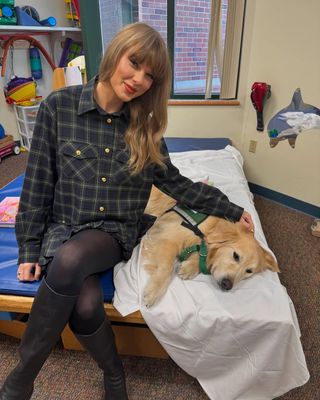 Taylor Swift poses with a service dog at Children's Mercy hospital