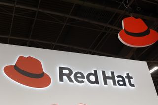 Red Hat logo on an illuminated sign above a conference hall