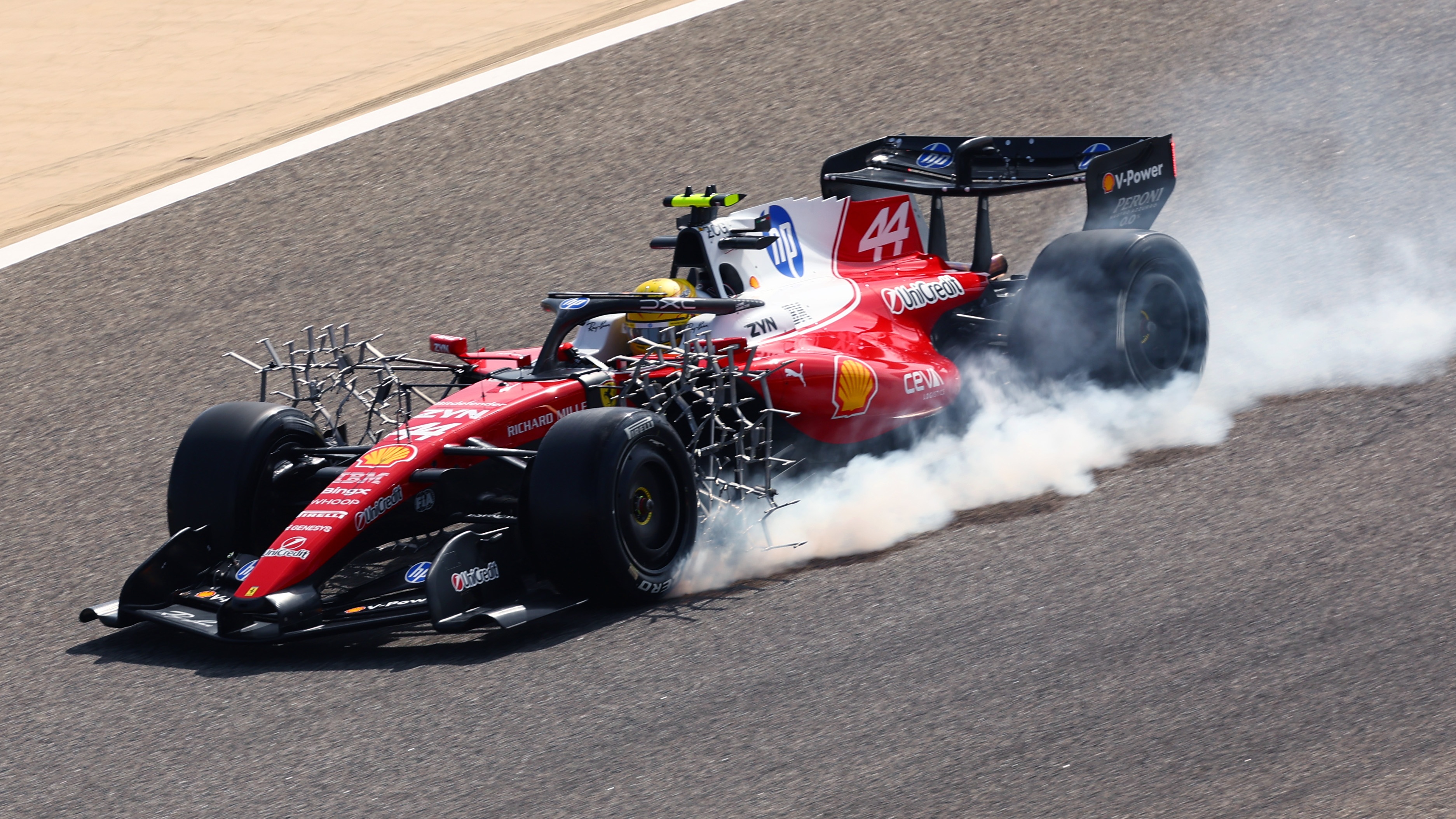 Lewis Hamilton of Great Britain driving the (44) Scuderia Ferrari SF-26 locks a wheel under braking during day one of F1 Testing at Bahrain International Circuit on February 11, 2026 in Bahrain, Bahrain.