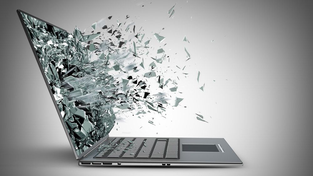 A laptop with its screen exploding, viewed from the side.